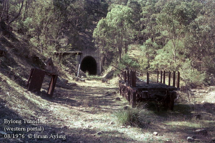 Remains of abandoned construction equipment outside the western portal of Bylong Tunnel in 1976. The bore was incomplete and flooded, blocking access.