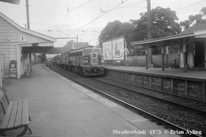 
Timber waiting rooms adorned both platforms at Meadowbank in this view looking
south in 1973. The ticket office was at the left, out of view. The building
visible above the locomotive is a railway residence which stands on the site
of the current day commuter car-park. The original Parramatta River bridge can
be seen in the distance.
