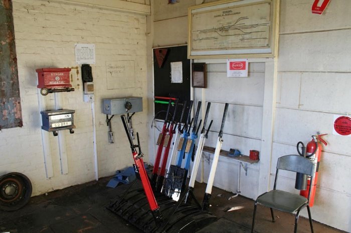 The interior of the signal box, showing the staff boxes, lever frame and yard diagram. The Nyngan-Cobar staff is missing, indicating that a train is in that section.