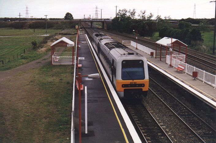 
A Newcastle-bound Endeavour set pauses momentarily at the unattended
station of Tarro.  The Coal Roads are visible at the far right.
