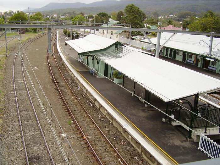The view from the footbridge at the Sydney end of Thirroul station looking down on the island platform.  The closest side (platform 3) is for local shuttle services to Wollongong and Port Kembla that start at Thirroul while the far side (platform 2) is the down mainline.  The line at the far left is a refuge used by the coal trains that regularly ply the Illawarra line.