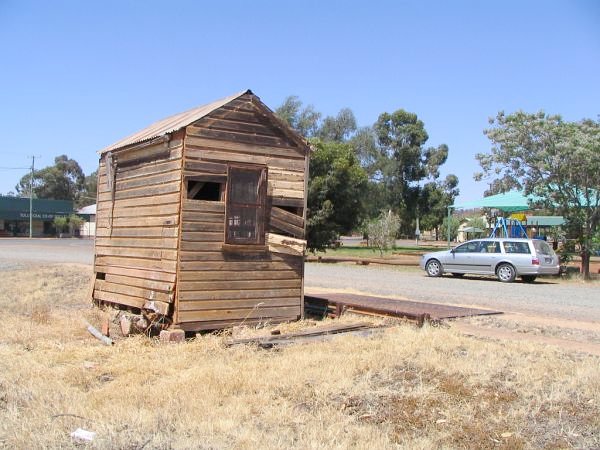 A decrepit weighbridge hut beside the track.