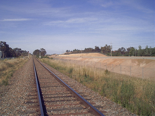 The view looking north towards Sydney. The signals in the photo are located at 642.350; he platform was on the down side to the right in this photo (4 metres down from the signals). Nothing remains of the platform at all. The racecourse is approx 150m away from the line. On the right is the construction of the new Hume Highway.