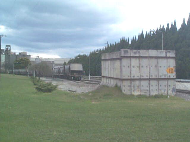 
A closer view of the tail end of a train in the cement works, and one of the
unusual concrete structures at the entrance to the yard.
