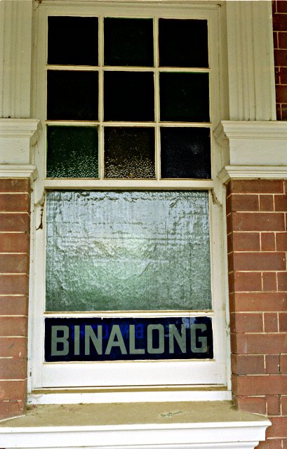 A glass name plate on a window of Binalong Station.