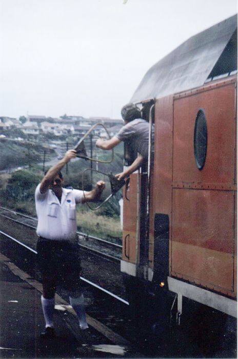 An integral part of single line rail operation was the exchanging of the
staff at a safeworking point. A classic pose is shown here at Bombo in 1986
as the up South Coast Daylight slowly trundles through.
