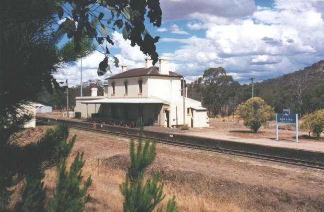 
A view of the station building and Countrylink signage through trees.
