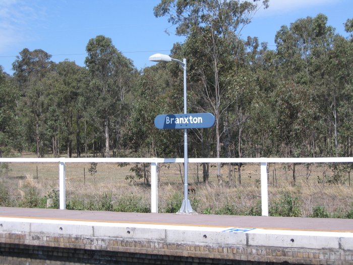 The modern station name board appears to have ben repainted by hand.