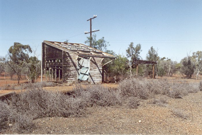 A view looking across at the burnt-out station building, still featuring its name board.