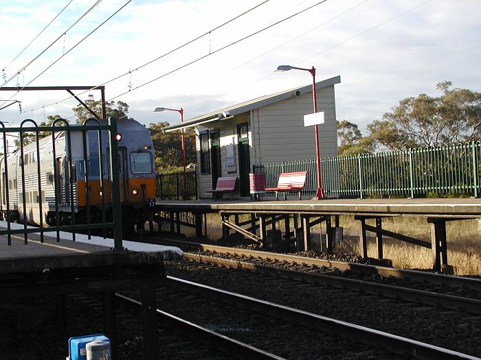 
A city-bound inter-urban "V" set moves though the up platform in the late
afternoon shot.
