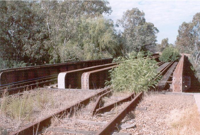 Just south of the station the main south and Corowa branch lines cross the Billabong Creek on separate iron bridges.  The left one carries the still-in-use main south line and the right one the now disused Corowa branch.
