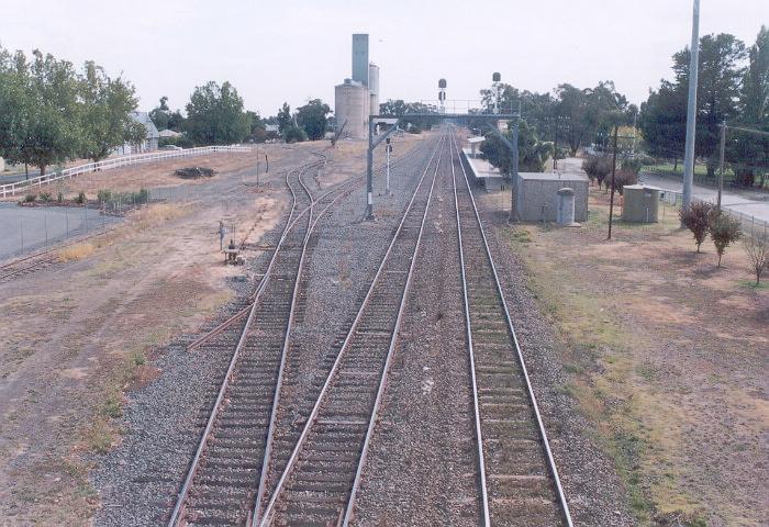 The view of the Culcairn yards in the vicinity of the station as seen from the overbridge looking north.  The station, still in use by Countrylink is on the right.  The remains of a loading bay, now wearing a white rail fence, is opposite the station on the far left.