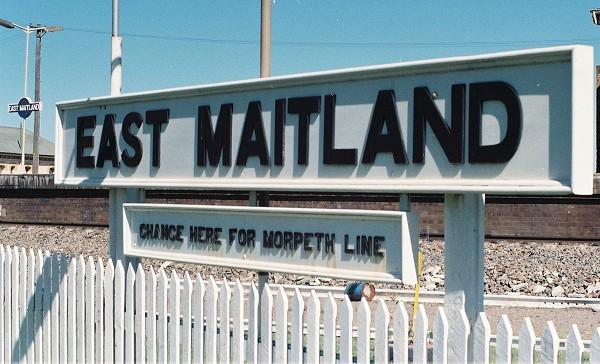 The station sign on the branch line platform. The live platforms are visible in the background.