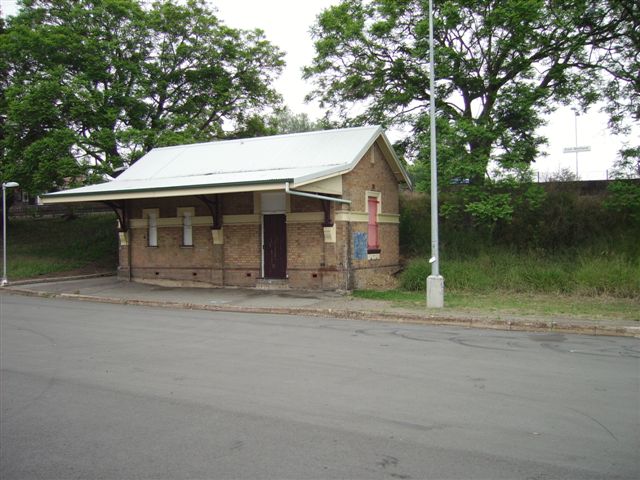 On the northern side of East Maitland, looking to the south. This building is adjacent to the subway access to the island platform. A station nameboard is just visible in the background.