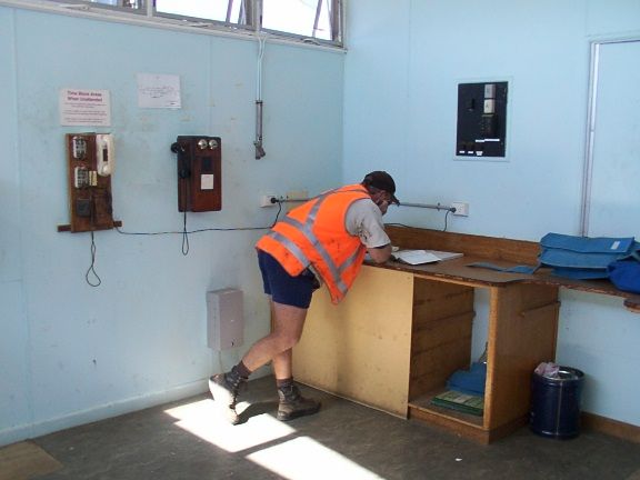
A track maintence worker consults a log book in the safeworking room
at the station.
