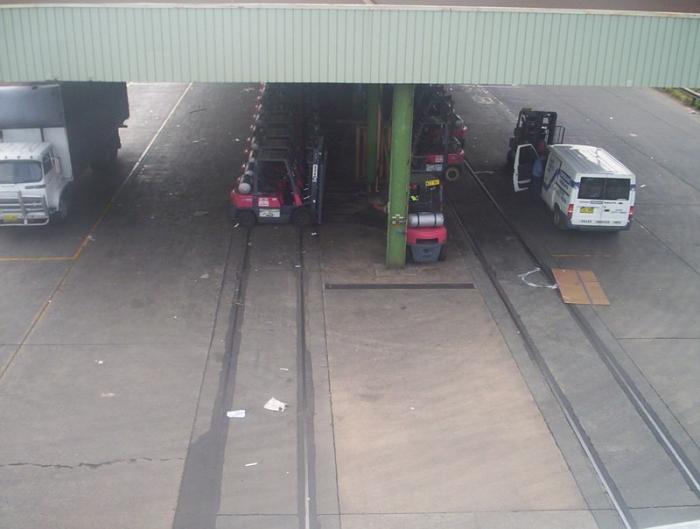 
The view looking down to the shed over No 2 Siding (left) and No 1 Siding
(right). Now used as under-cover parking for forklifts. This shot is taken
facing the city.
