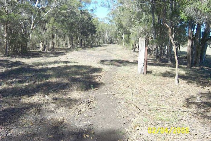 The line before this site remains single track through an open grazing field with a number of old sleepers still in place. The line after this site reverts back to single track and high embankments, this is the only area along the line with enough space for sidings.