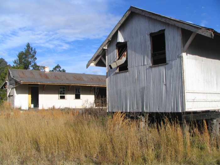 A galvanised iron goods shed near the station building.  Note the loading chute through the window.