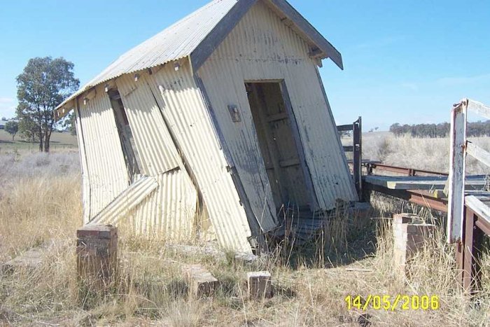 The meagre waiting shed has fallen off its brick piers.