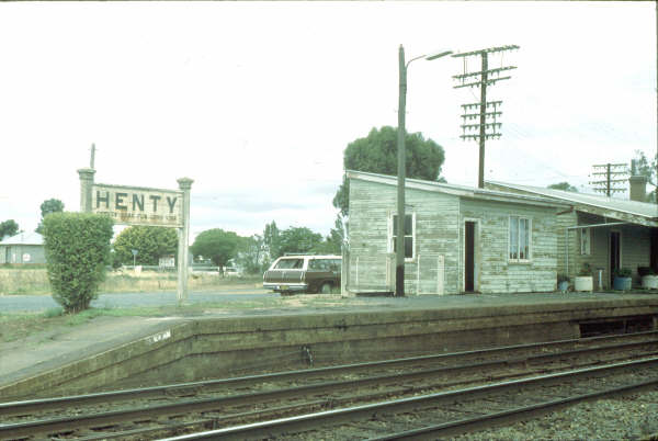 Henty Signal Box in need of repair and a paint job sits near the station sign which says "Change here for the Rand line".