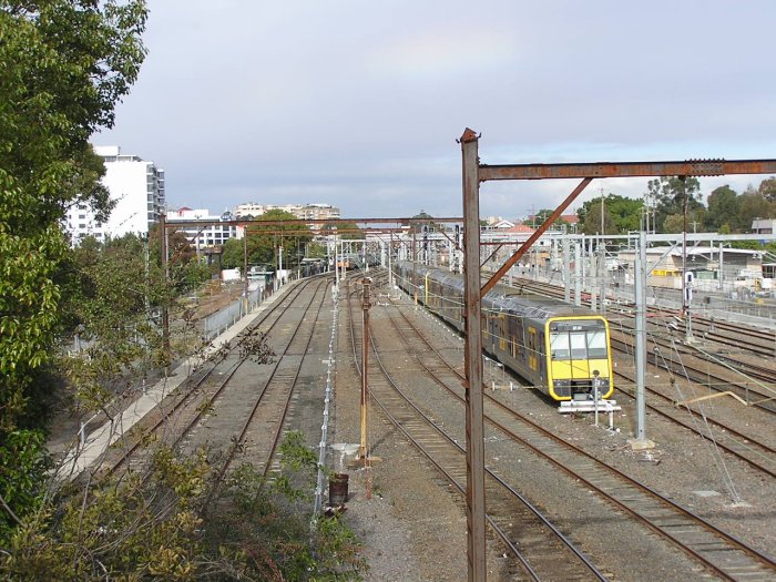 Northern Line, looking south from Bridge Road overpass, Hornsby. The tracks to the left of the train are the Nos 3 and 2 Up sidings and the Outwards and Inwards Car Shed roads. Note the elevated water tank in the left distance, adjacent to the small white building.