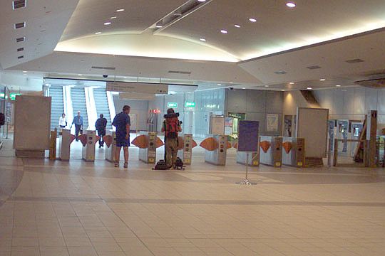 
Looking back at the gates from the inside station. The ticket machines
opposite the ticket counter are visible. Note the ticket barriers are
orange in colour and not the ubiquitous red.
