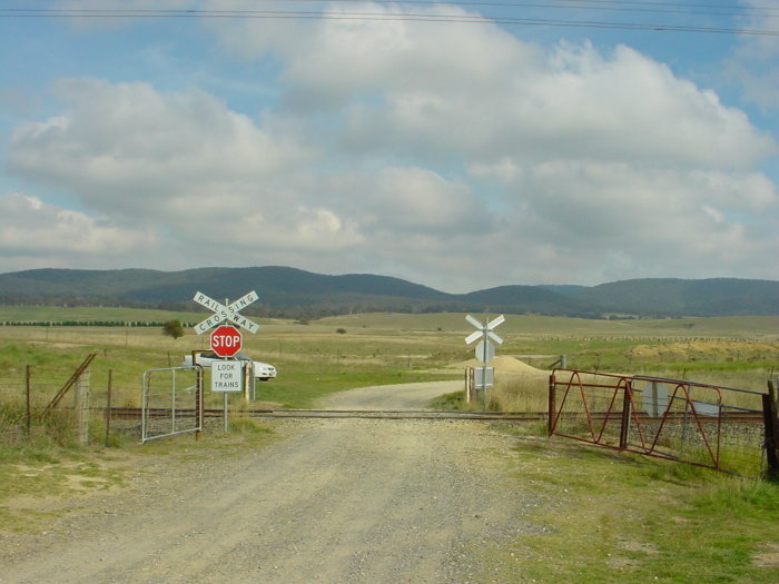 The view looking west at the level crossing next to the one-time station location. 