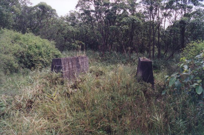 
Several hundred metres to the north of the station, a pair of concrete
pylons show where the line crossed one of the creeks leading onto Jewells
Swamp.
