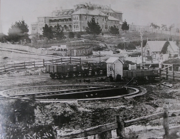 A photo of a photo hanging in a corridor of the Carrington Hotel at Katoomba. The inscription under photo reads "Katoomba Turntable and Carrington Hotel circa 1890".