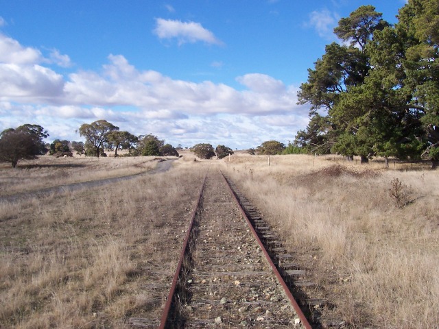 The view looking back towards Goulburn. The station and platform are marked by the white post to the right of the track. The white post further away is the half kilometre peg. Just visible opposite this is the loading bank.
