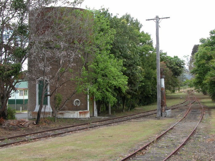 
The water tower, unusually a circular brick base with a circular
steel tank on top. An incomplete water column is on the right. The siding
disappearing into the distance ends at the turntable.
