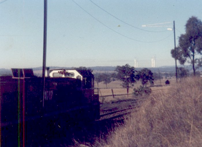 A 47 class loco at the head of a train being loaded. Water vapor from Bayswater Power station is plainly visible.