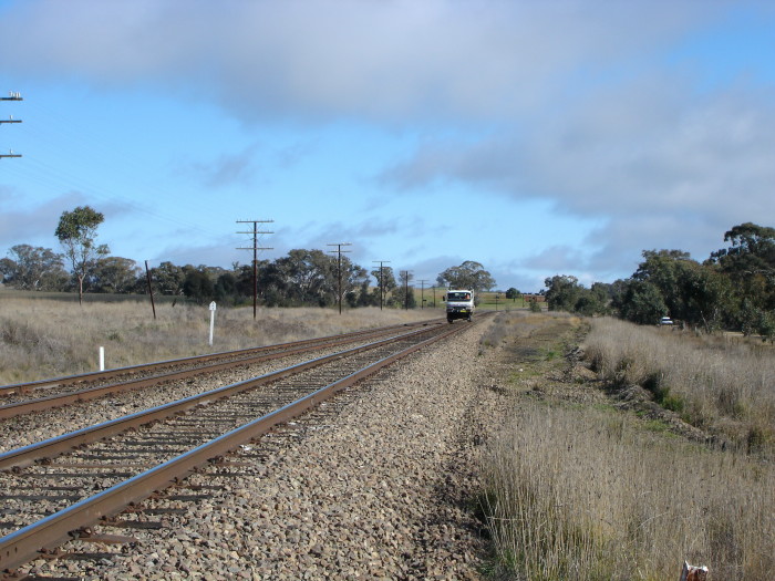 The view looking west as a hi-rail truck passes the one-time station location.