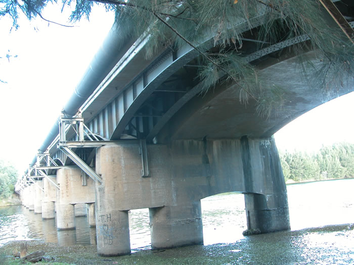 The view looking west under the bridge over the Nepean River.  The metal girders originally carried the railway, with the concrete arch later added for road traffic.  Eventually road traffic took over the whole bridge.