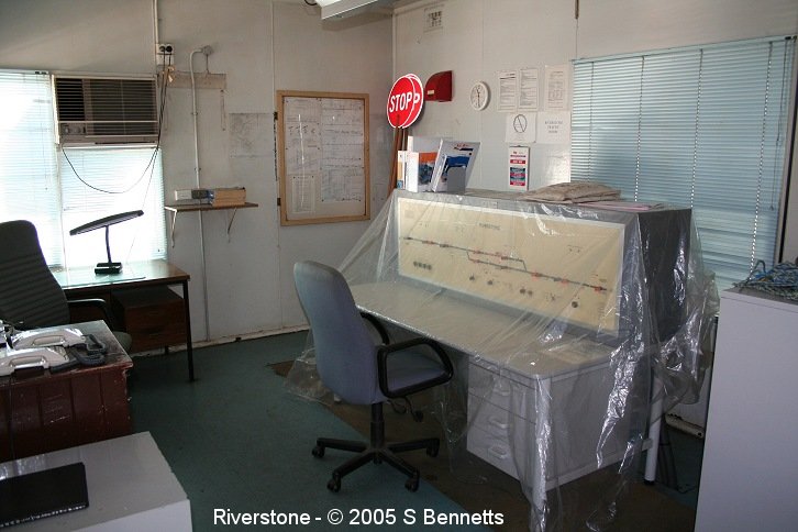 An interior shot of the part time signal box at Riverstone. A desk with a new board covered with protective plastic sits where old lever frame was.