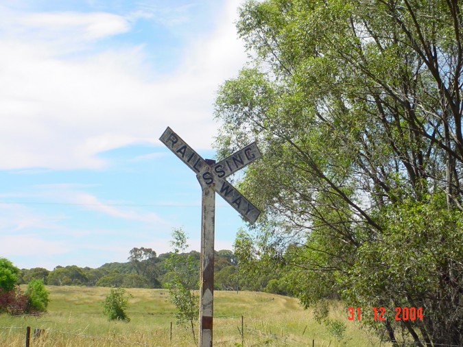 
The worn sign warning of the level crossing.
