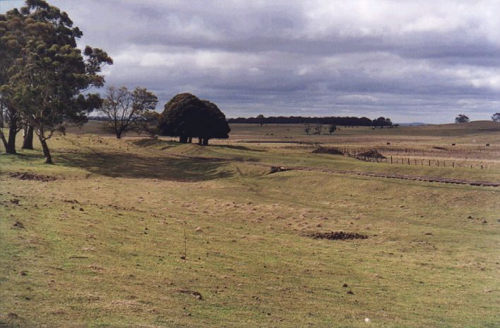 
The location of the junction for the branch line to Taralga.  The bank
behind the line is the remains of the formation, which curved around to the
right of the stand of trees and out to the the right of the frame.
