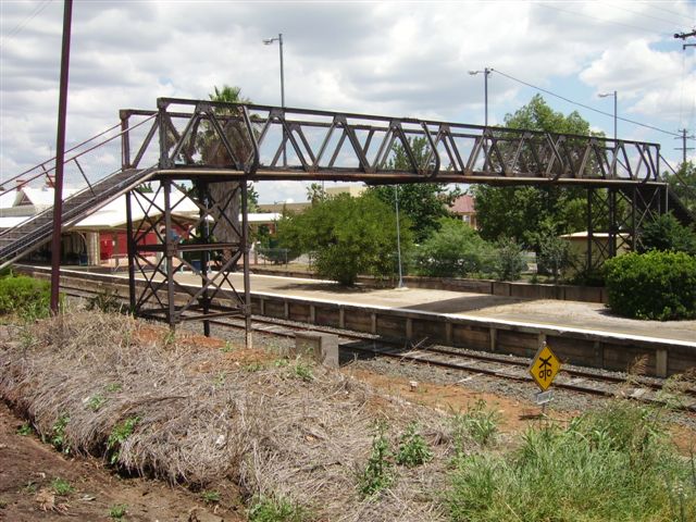 A view (looking in the direction of Armidale) of the attractive and well-kept station and the all-steel footbridge linking two streets, not directly accessing the platform.