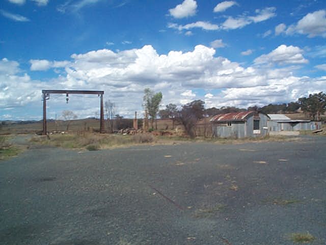 
The yard is mainly buried under gravel and grass.  This view shows the gantry
crane, the remains of the station and platform, the lamp hut, and another
unidentified building.
