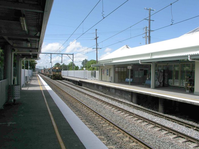 The view looking north as a south-bound freight train passes through the station.