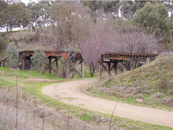 For part of the way the Tumut Branch Line runs parallel to the Snowy Mountains Highway.  This timber bridge, now cut in the middle, is located next to the highway about 10 kilometres west of Tumut; the view being of the southern side of the bridge.