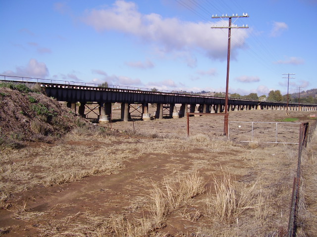 The Main Southern Line approaches the Murrumbidgee River Bridge at Wagga Wagga over a concrete and steel viaduct.  A view on the northern side of the river looking towards Wagga Wagga.
