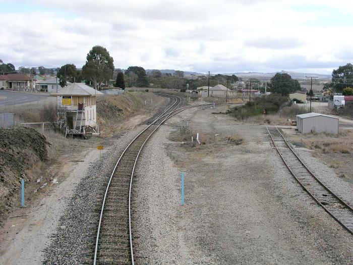 
The view looking west towards the old Wallerawang West signal box and the
junction of the line to Gwabegar.  The siding is now used for
per-way storage.  The area to the right of the main line was once the
site of extensive loco service facilities include ash and inspection pits,
a water tank, coal stage and a 60' turntable.
