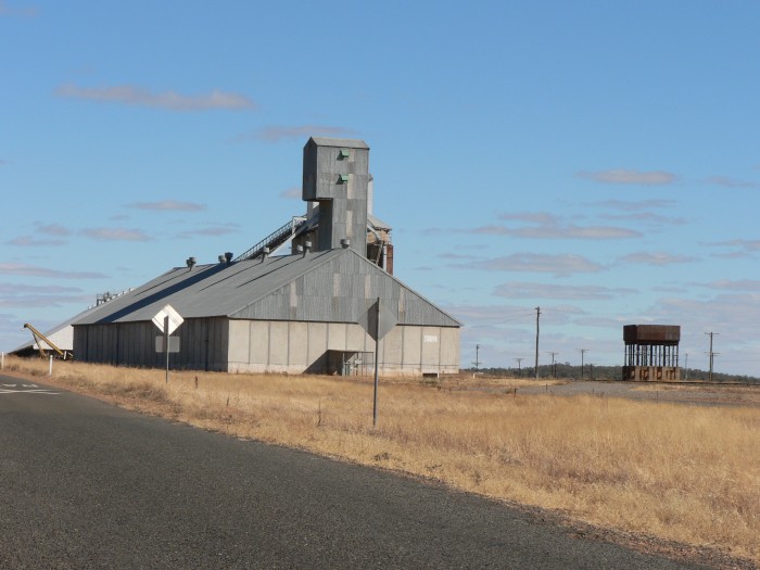 The water tank is dwarfed by the large silo complex.