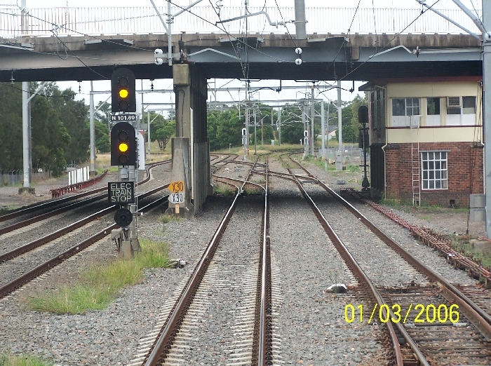 Woodville Junction Signal Box sits beneath Donald Street bridge and is completely invisible from the roadway above. The junction is visible in the background:  straight ahead the line curves  to the right to Hamilton and Newcastle, with a turnout to the left towards Islington Junction and further on to Maitland.