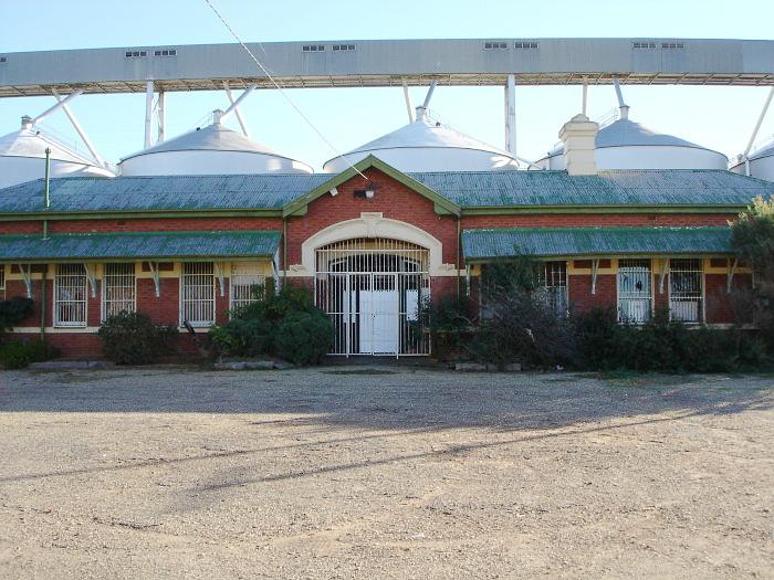 A close-up view of the station building, overshadowed by a set of grain silos.